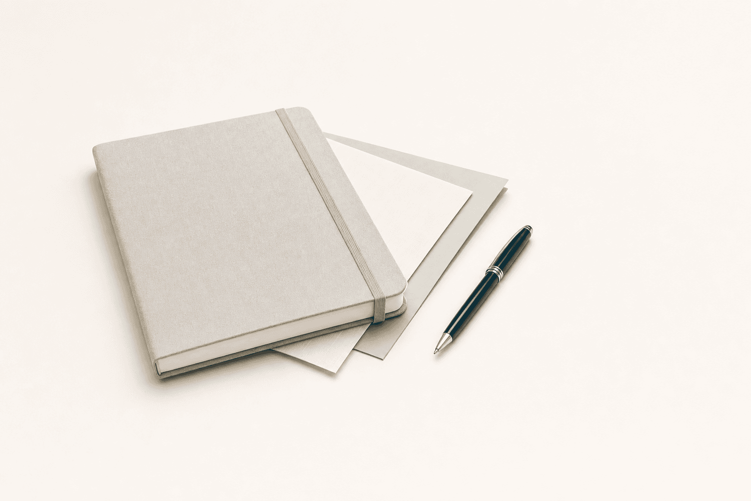 Representative photograph of a linen notebook, layered papers, and a pen on a desk.